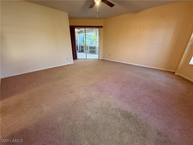 carpeted empty room featuring a ceiling fan and baseboards