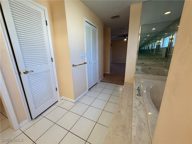 bathroom featuring a garden tub, visible vents, ceiling fan, baseboards, and tile patterned floors