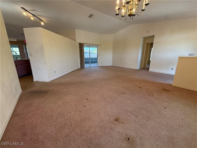 unfurnished room with visible vents, baseboards, carpet, vaulted ceiling, and a chandelier