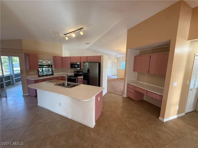 kitchen featuring lofted ceiling, light countertops, appliances with stainless steel finishes, a sink, and wallpapered walls