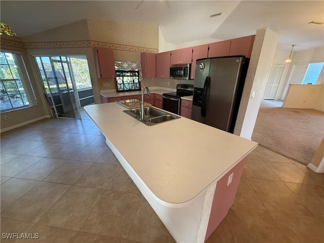 kitchen featuring stainless steel appliances, lofted ceiling, light colored carpet, and a sink