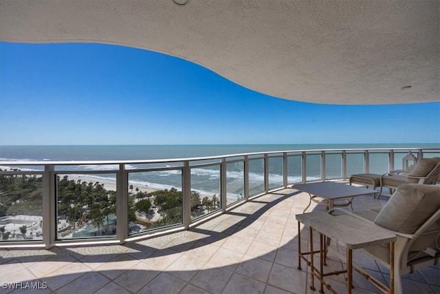 balcony featuring a water view and a beach view