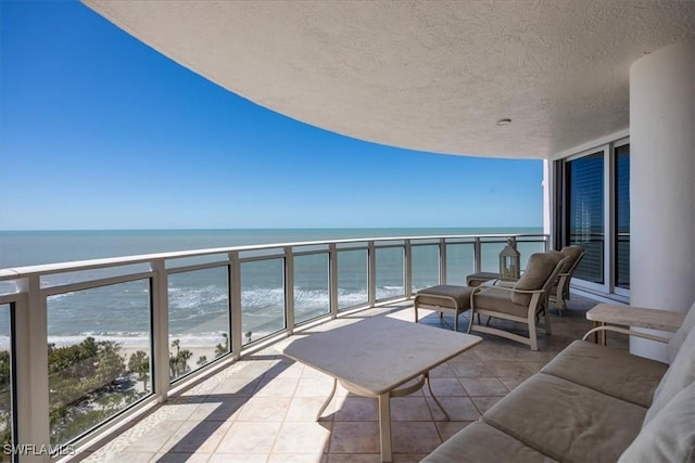 balcony with a water view and a beach view