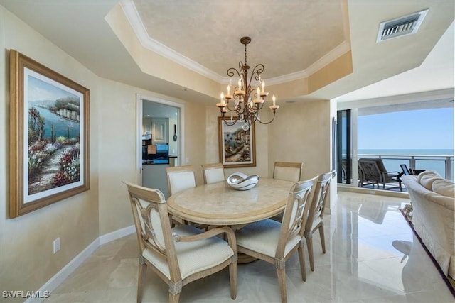 dining room with a tray ceiling, crown molding, baseboards, and visible vents