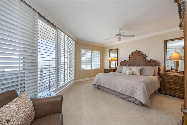 carpeted bedroom with ceiling fan, baseboards, and ornamental molding