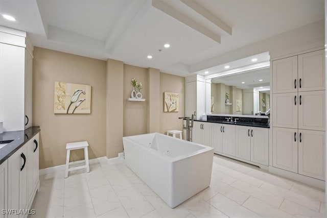 interior space featuring marble finish floor, recessed lighting, baseboards, a freestanding bath, and vanity