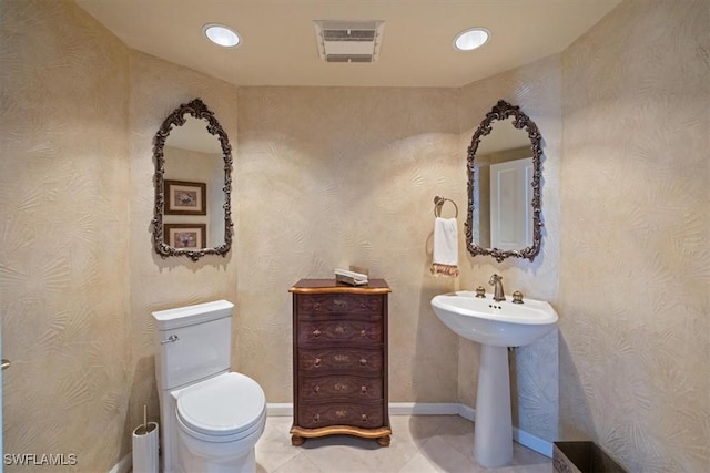 half bath with toilet, recessed lighting, visible vents, and a sink