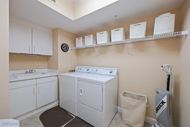 washroom with cabinet space, light tile patterned floors, independent washer and dryer, and a sink