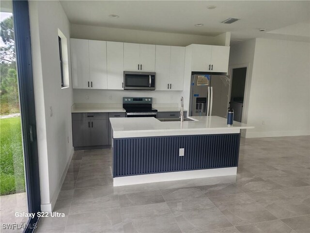 651 Knapp St, Lehigh Acres, FL 33974 - kitchen with visible vents, an island with sink, appliances with stainless steel finishes, light countertops, and a sink