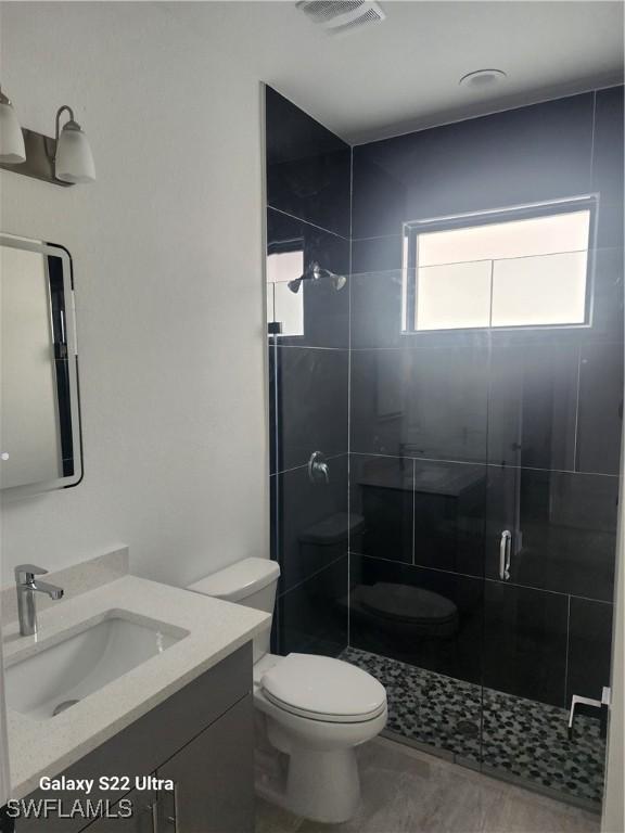 651 Knapp St, Lehigh Acres, FL 33974 - bathroom with toilet, a stall shower, visible vents, and vanity
