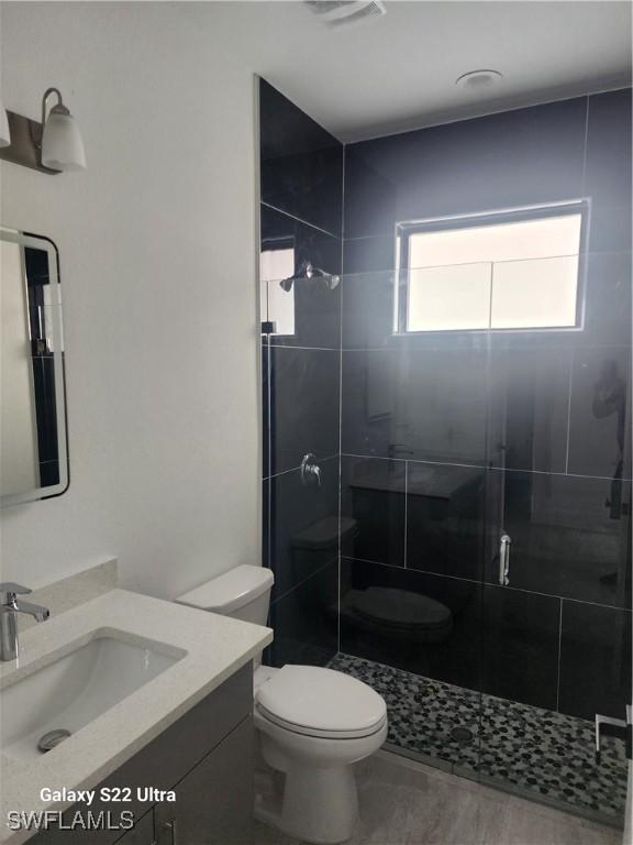 651 Knapp St, Lehigh Acres, FL 33974 - bathroom featuring visible vents, vanity, a shower stall, and toilet