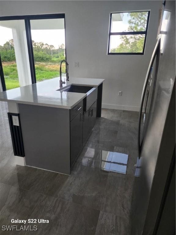 651 Knapp St, Lehigh Acres, FL 33974 - kitchen featuring a wealth of natural light, freestanding refrigerator, light countertops, and a sink