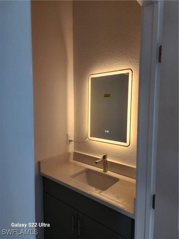 651 Knapp St, Lehigh Acres, FL 33974 - bathroom featuring a textured wall and vanity