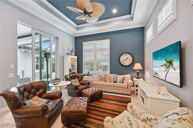 living area featuring a raised ceiling, a ceiling fan, crown molding, and tile patterned flooring