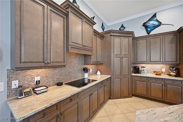 kitchen with light tile patterned floors, black electric stovetop, tasteful backsplash, and crown molding