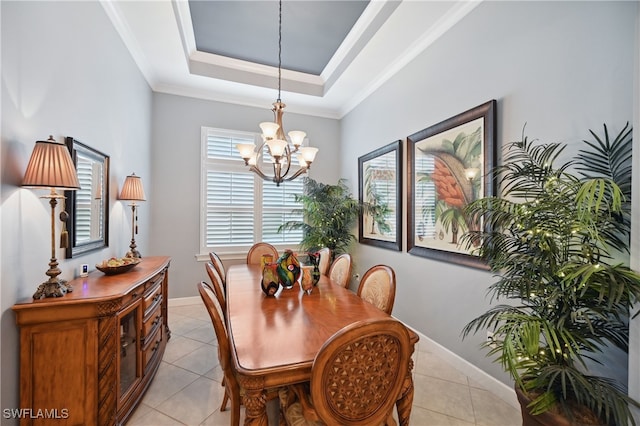 dining space with baseboards, a chandelier, a tray ceiling, ornamental molding, and light tile patterned flooring