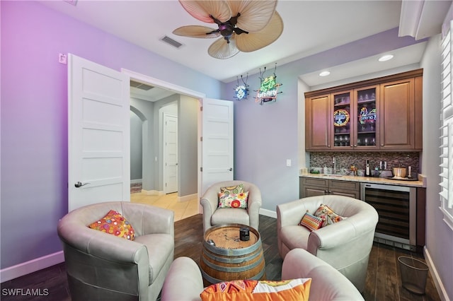 bar with tasteful backsplash, visible vents, wine cooler, indoor wet bar, and arched walkways