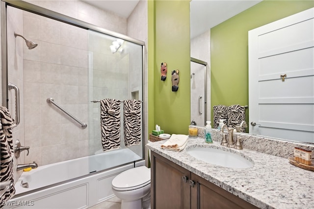 bathroom with combined bath / shower with glass door, toilet, and vanity