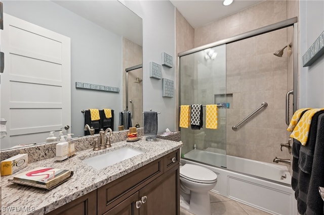 bathroom with tile patterned floors, bath / shower combo with glass door, vanity, and toilet