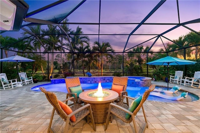 view of patio / terrace with a lanai and a pool with connected hot tub