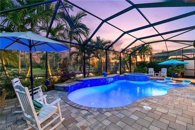 view of swimming pool with a lanai, a pool with connected hot tub, and a patio