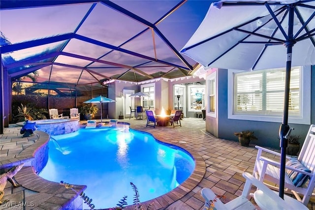 view of pool with a patio, a fire pit, a lanai, and a pool with connected hot tub