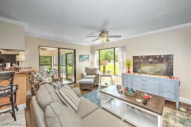 living area featuring ornamental molding, baseboards, and a ceiling fan