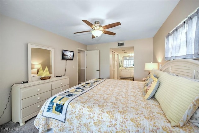 bedroom with a ceiling fan, visible vents, carpet floors, and ensuite bathroom