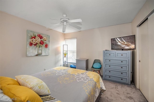bedroom with a ceiling fan, a closet, and light colored carpet