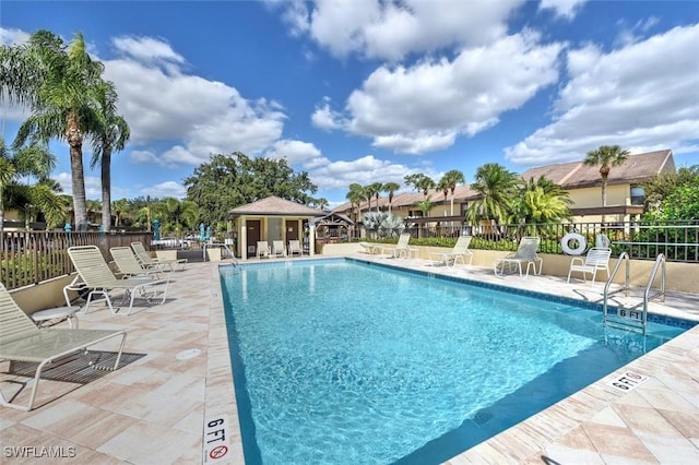pool with a patio area and fence