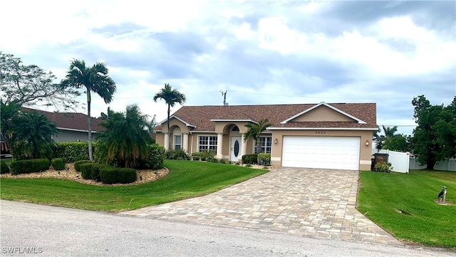 single story home with a garage, fence, decorative driveway, stucco siding, and a front lawn