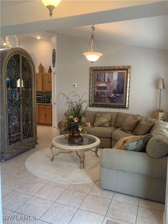 living area with light tile patterned floors and vaulted ceiling