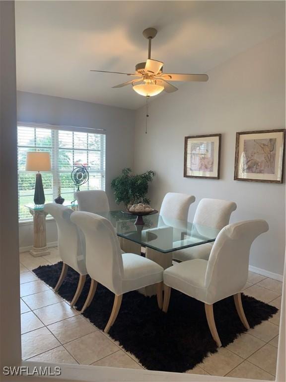 dining room with lofted ceiling, light tile patterned floors, baseboards, and a ceiling fan