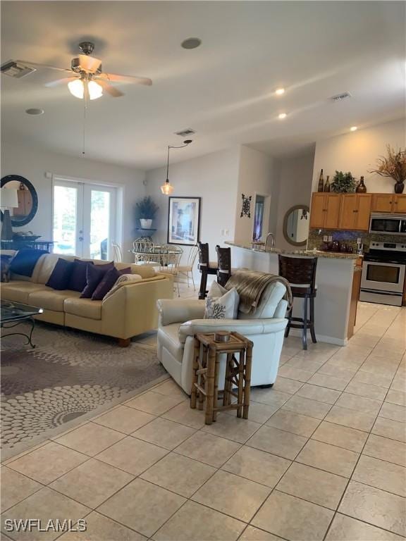 living room featuring lofted ceiling, visible vents, and light tile patterned flooring