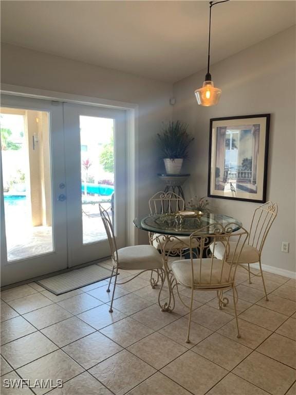 dining space featuring french doors, light tile patterned flooring, and baseboards