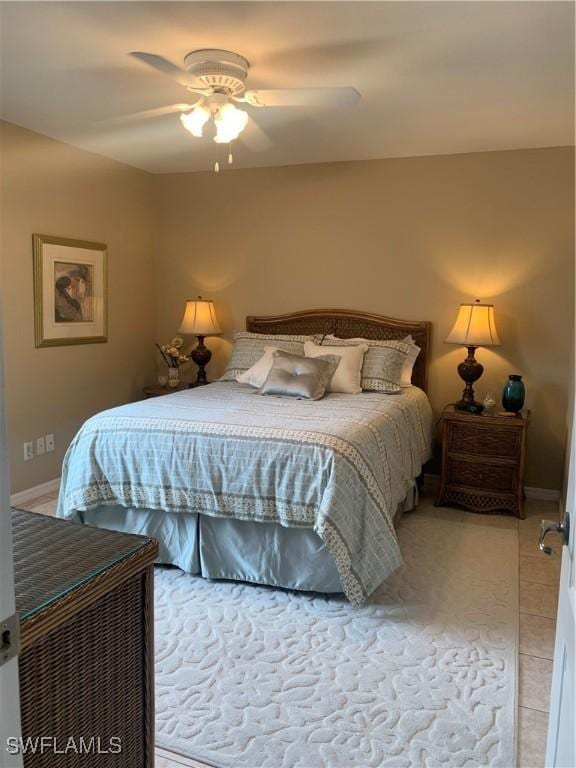 bedroom with light tile patterned flooring, a ceiling fan, and baseboards