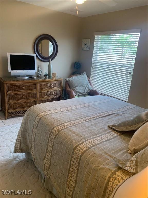 bedroom with ceiling fan and light tile patterned flooring