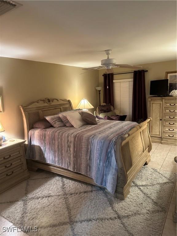 bedroom with light tile patterned floors, visible vents, and a ceiling fan