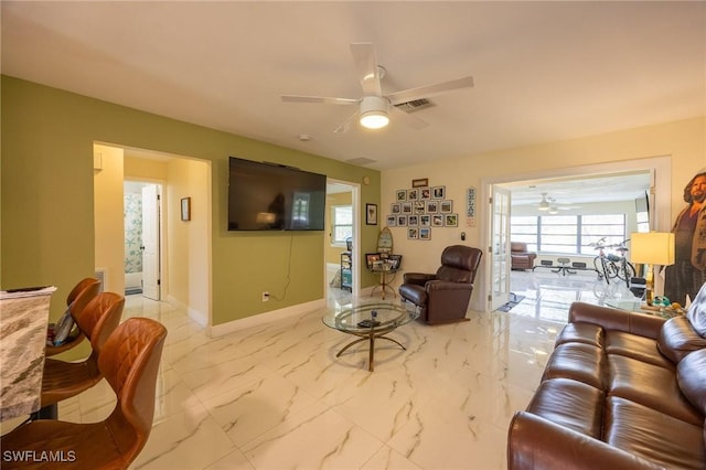 living room featuring visible vents, baseboards, marble finish floor, and a ceiling fan