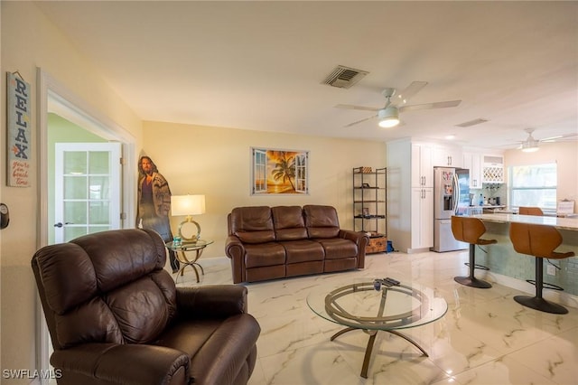 living area featuring visible vents, marble finish floor, and ceiling fan