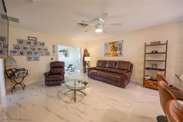 living area featuring visible vents, marble finish floor, and a ceiling fan