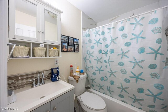 full bathroom featuring vanity, tasteful backsplash, shower / tub combo with curtain, and toilet