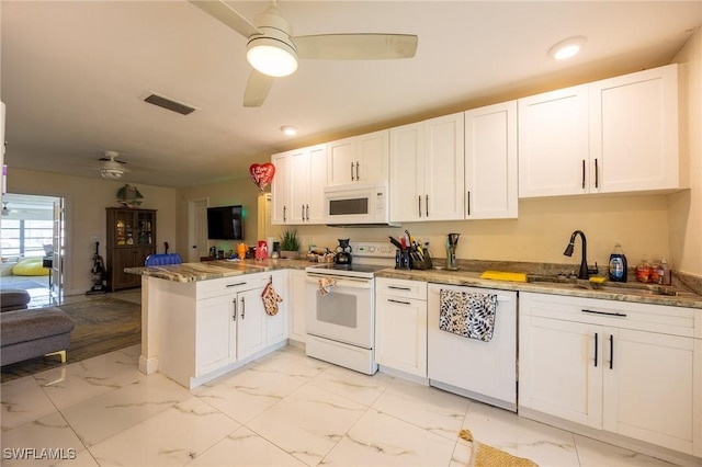 kitchen with a sink, visible vents, white appliances, and marble finish floor