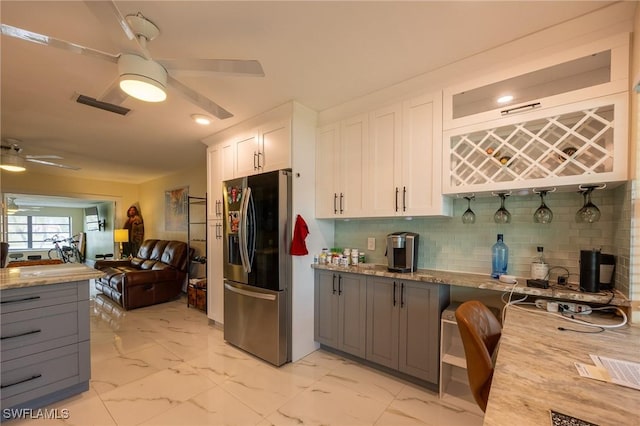 kitchen featuring visible vents, marble finish floor, a ceiling fan, and stainless steel fridge