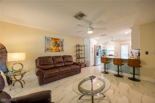 living room with a ceiling fan, visible vents, marble finish floor, and baseboards