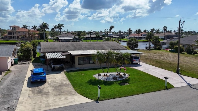 view of front of house featuring a front yard, concrete driveway, and a residential view