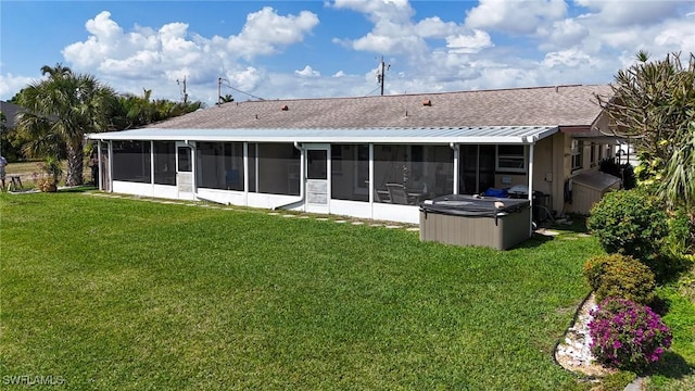 back of house with a lawn, a hot tub, and a sunroom