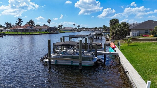 dock area with a residential view, a lawn, and a water view