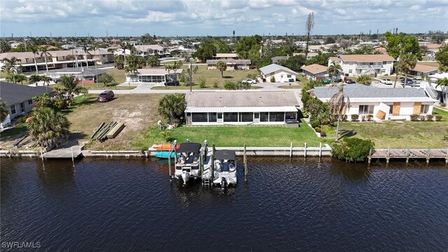 drone / aerial view featuring a residential view and a water view