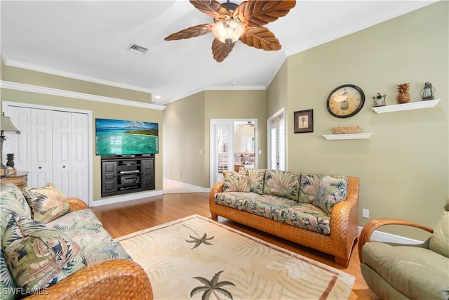 living room with visible vents, a ceiling fan, wood finished floors, crown molding, and baseboards